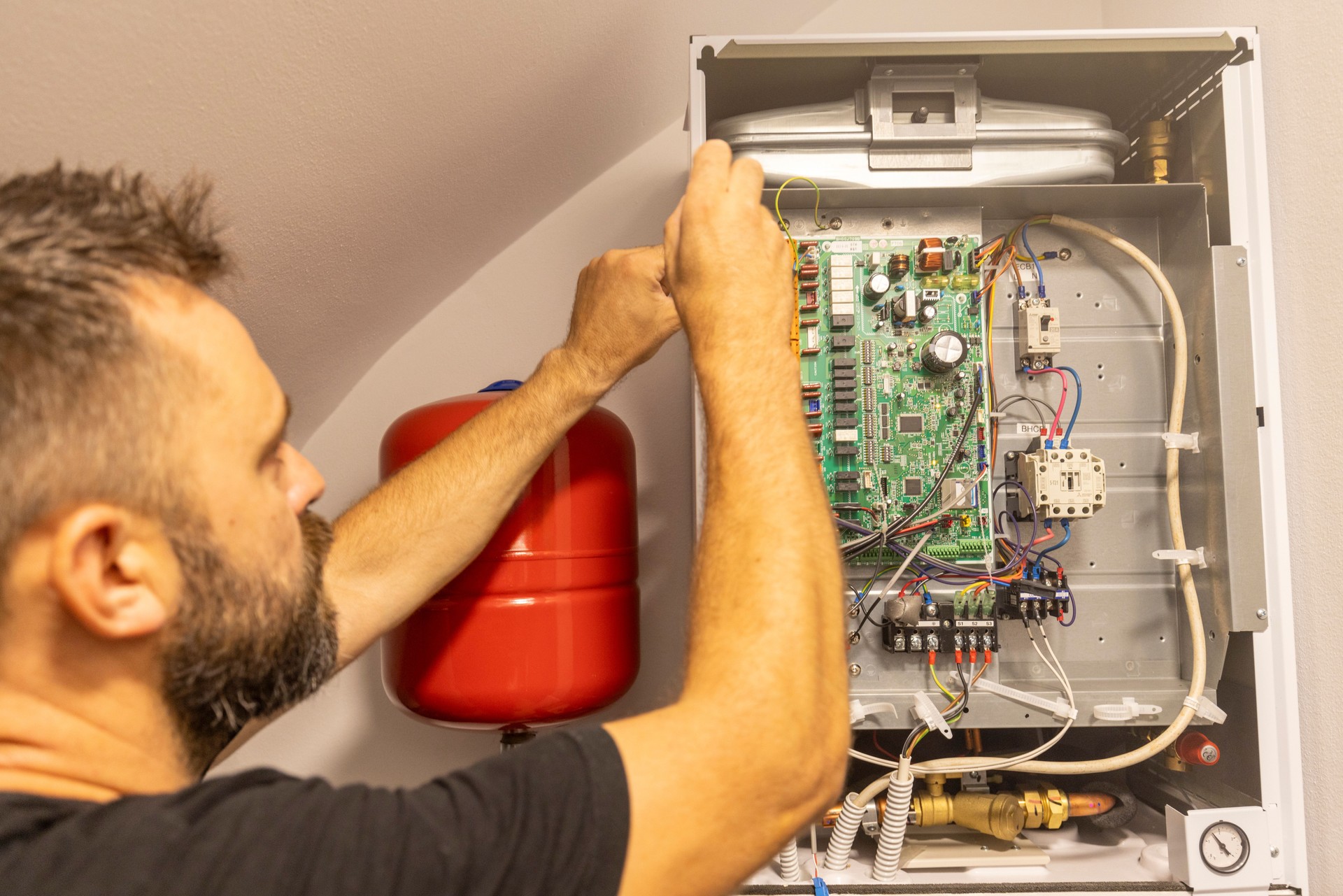 A male technician is repairing a heat pump